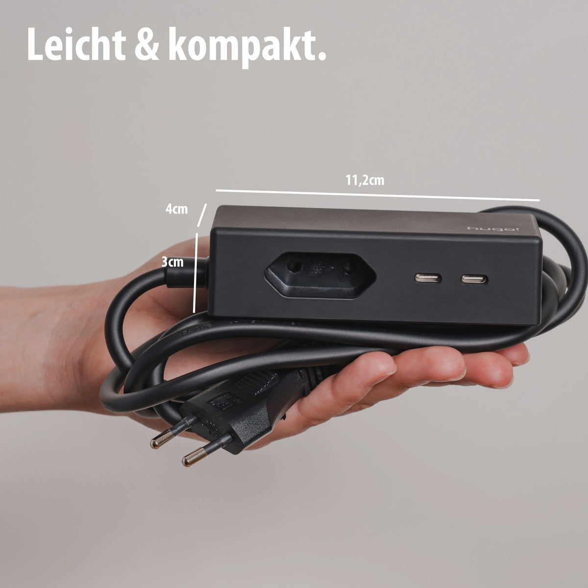 Kompakter hugo! TRAVEL in der Hand mit Maßen 11,2 × 4 × 3 cm.