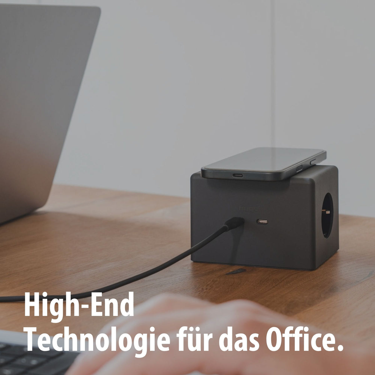 Schwarzer hugo! ONE mit Smartphone am Schreibtisch.