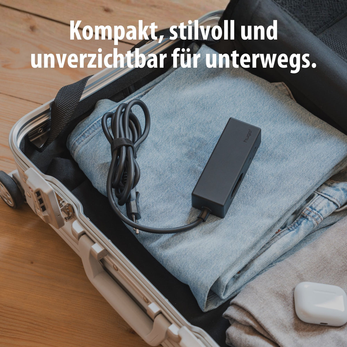 Kompakter hugo! TRAVEL mit Kabel im geöffneten Reisekoffer.