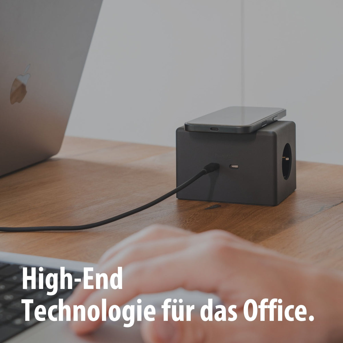 Schwarzer hugo! ONE mit Smartphone am Schreibtisch.