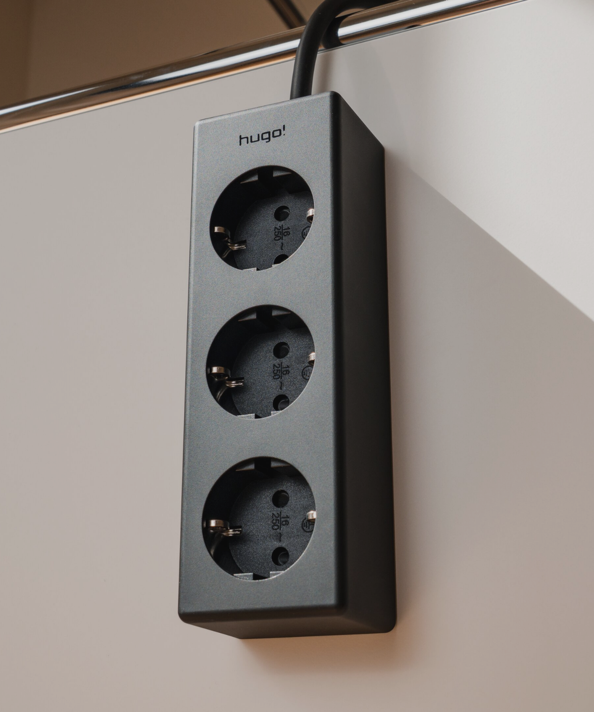 hugo! magnetic Steckdosenleiste in deep black mit drei Steckdosen, magnetisch befestigt.