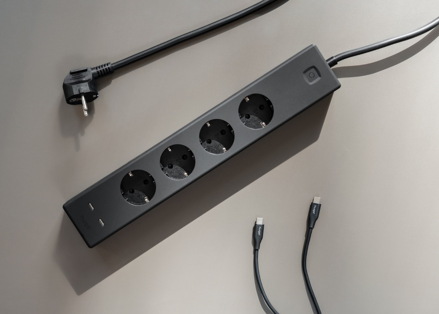 hugo! SOCKET in deep black mit vier Steckdosen, zwei USB-C-Anschlüssen und Schalter.